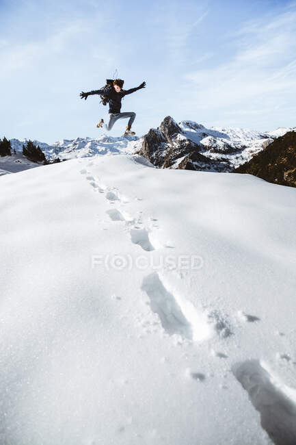 Hombre saltando en la nieve - foto de stock
