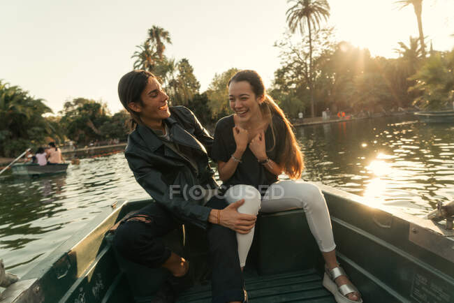 Portrait of smiling young couple having fun in wooden boat in river. — Stock Photo