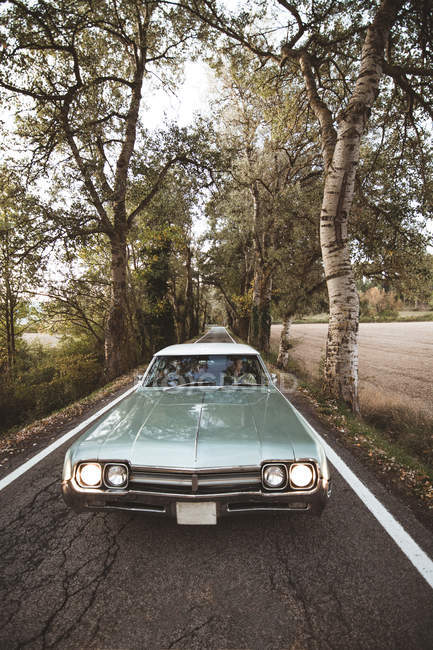 Vintage car moving on asphalt rural road — Stock Photo