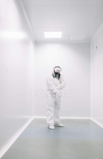 Científico poniéndose guantes antes de trabajar en laboratorio - foto de stock