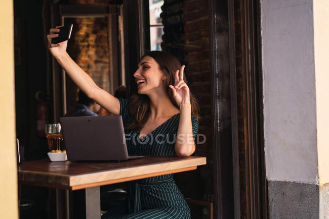 Mujer en la cafetería con tomar selfie - foto de stock