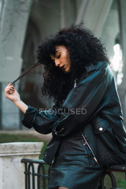 Side view of curly woman posing in city — Stock Photo