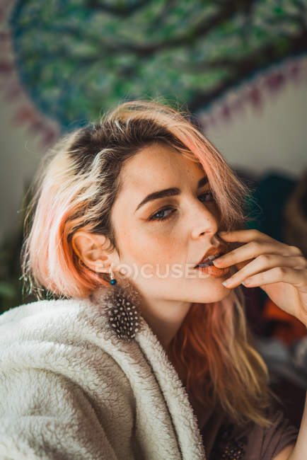 Retrato de mulher jovem com cabelo rosa posando com o dedo nos lábios — Fotografia de Stock
