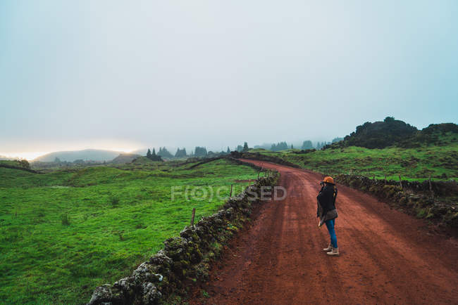 Woman standing on rural dirt road at countryside — Stock Photo