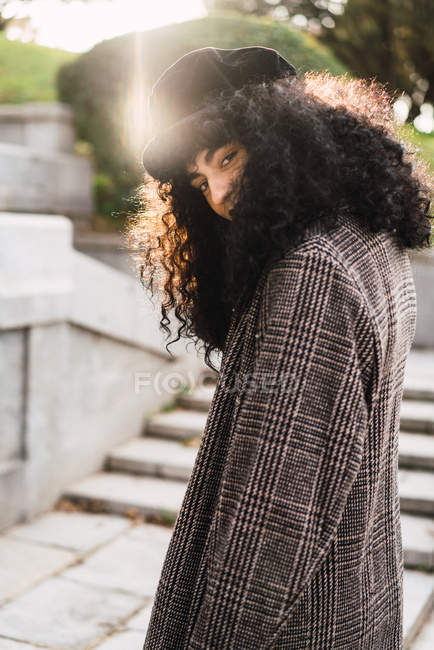 Pretty stylish woman walking in park and looking at camera — Stock Photo
