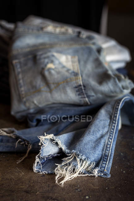Натюрморт з блакитними джинсами на темному столі . — стокове фото
