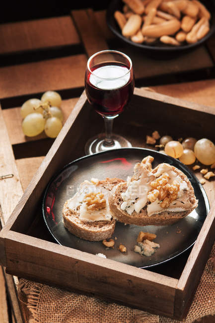 Натюрморт из ломтиков хлеба с сыром и вином — стоковое фото