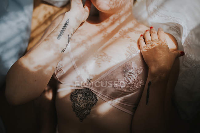 Mid section of woman with curtain shadow on body — Stock Photo