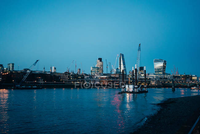 Blick auf den Stadtfluss mit Schiff und Wolkenkratzern in der Abenddämmerung — Stockfoto