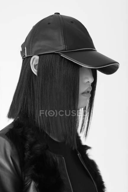 Mulher asiática elegante em cap posando em estúdio — Fotografia de Stock