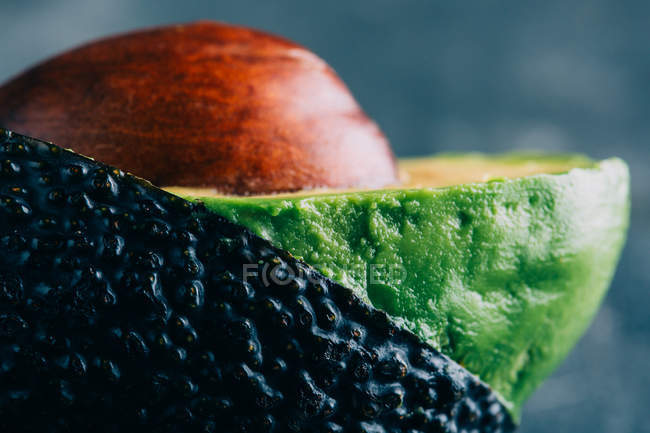 Geschnittene Avocado auf dunklem Hintergrund — Stockfoto