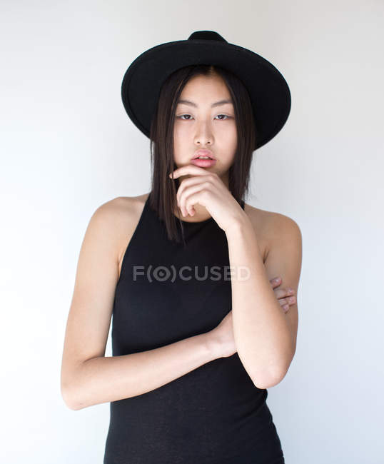 Jovem mulher asiática posando em estúdio com chapéu — Fotografia de Stock