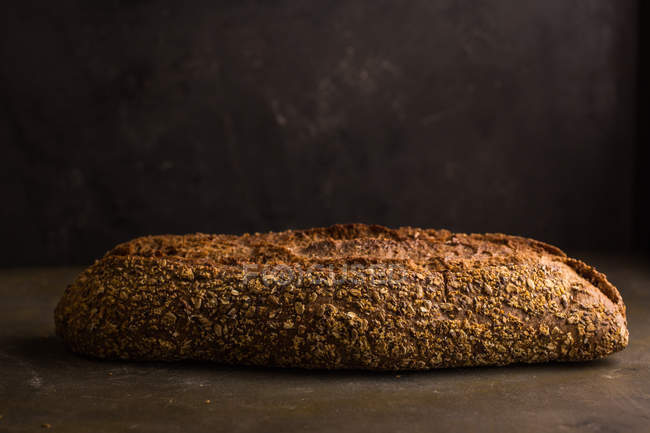 Bodegón de pan recién horneado sobre fondo oscuro - foto de stock