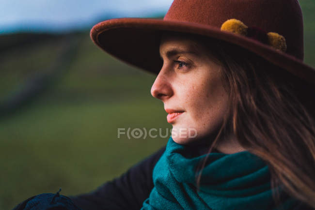 Мрійлива жінка позує на фоні зеленого поля — стокове фото