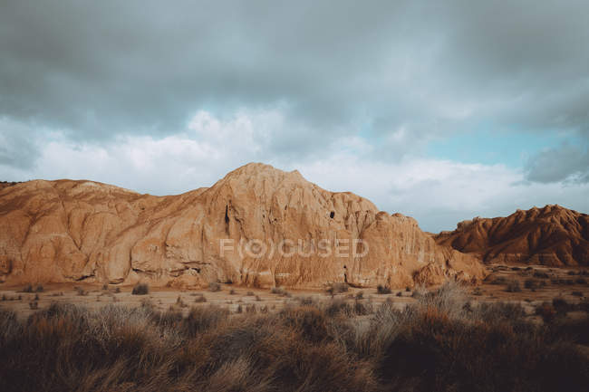 Пейзаж прерий с песчаными скалами под драматическим небом — стоковое фото