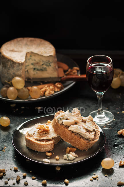 Still life of appetizer with cheese and glass of wine on table — Stock Photo