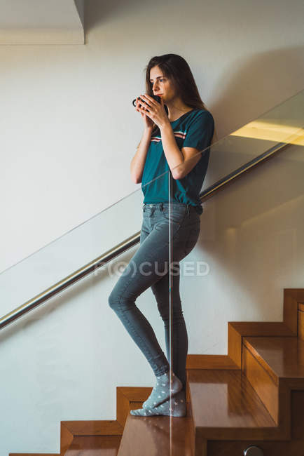 Vue latérale de la femme appréciant le café sur les escaliers — Photo de stock