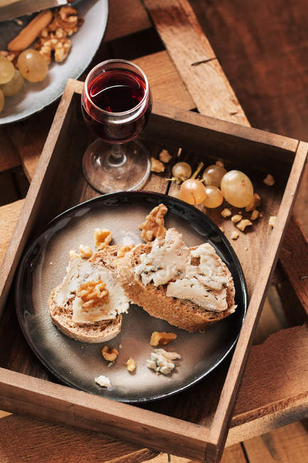 Différents apéritifs dans un plateau avec fromage, pain et vin — Photo de stock