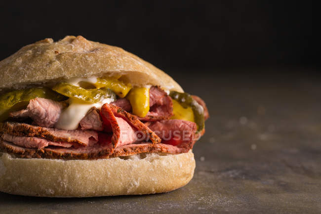 Crop pastrami sandwich with pickles and mustard — Stock Photo