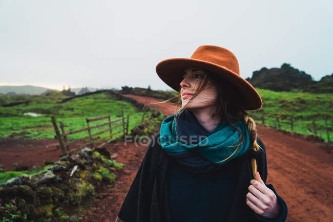 Mujer en sombrero caminando por el camino rural - foto de stock