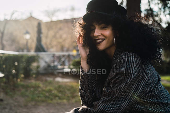 Jovem mulher elegante sorrindo para a câmera na cena da rua — Fotografia de Stock