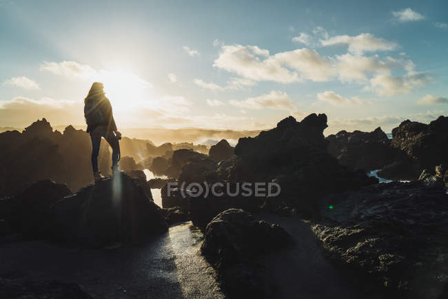 Silhouette einer Frau mit Kamera auf Klippen — Stockfoto