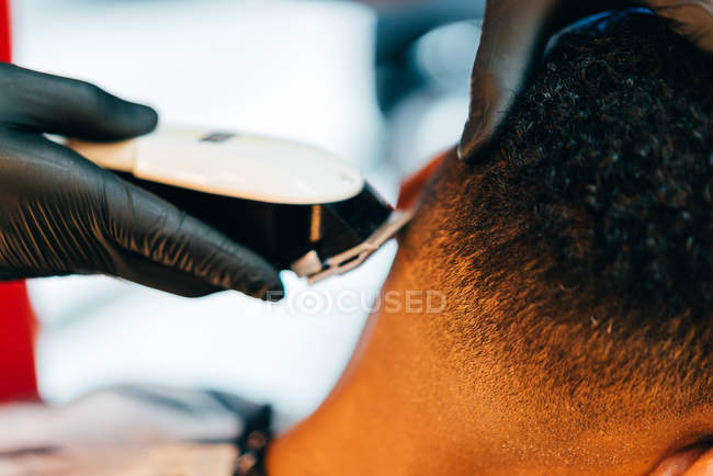 Friseur benutzt Pflegemaschine am Kopf des Kunden — Stockfoto