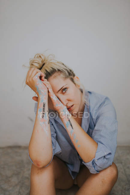 Mulher loira na camisa masculina apoiada nas mãos em tinta — Fotografia de Stock