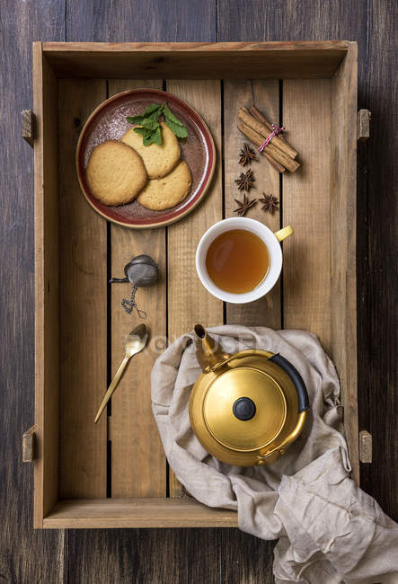 Tetera de cobre con taza de té verde y galletas en bandeja - foto de stock