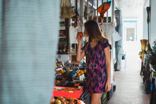 Жінка купує фрукти на вуличному ринку — стокове фото