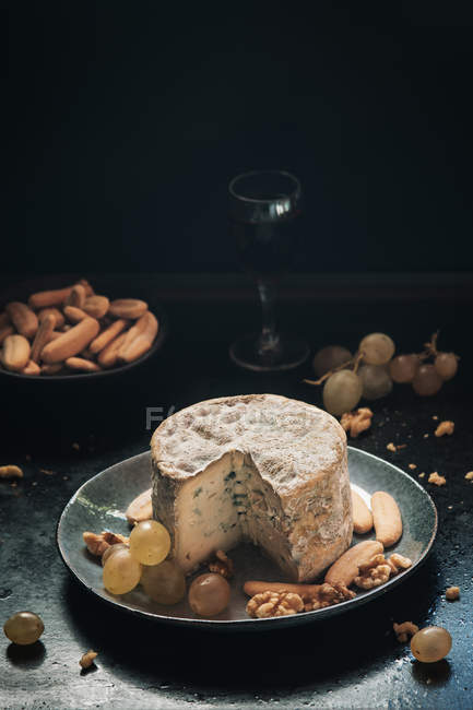 Still life of blue cheese with grapes and walnuts in plate — Stock Photo
