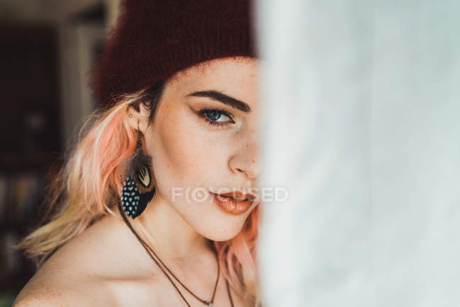 Verdunkeltes Porträt einer Frau mit rosa Haaren am Fenster — Stockfoto