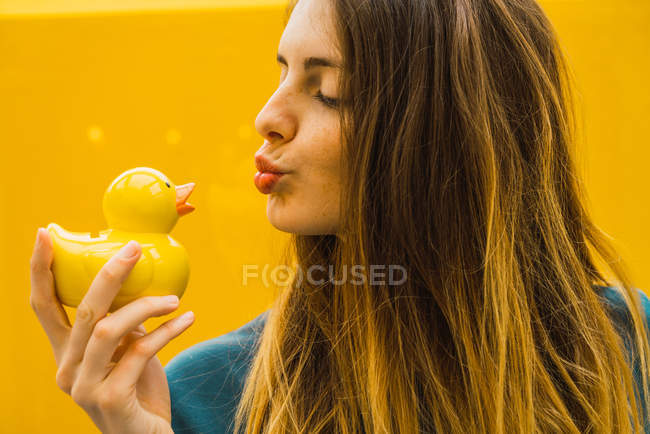 Молода жінка гризе гумовою качкою — стокове фото