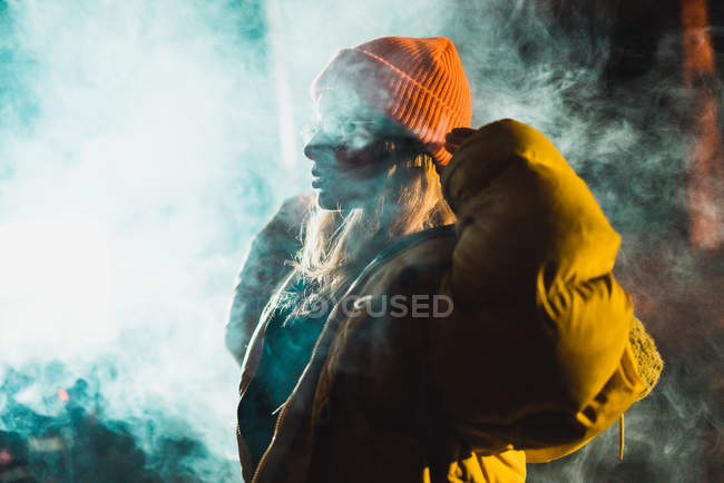 Side view of woman in vape cloud at night — Stock Photo