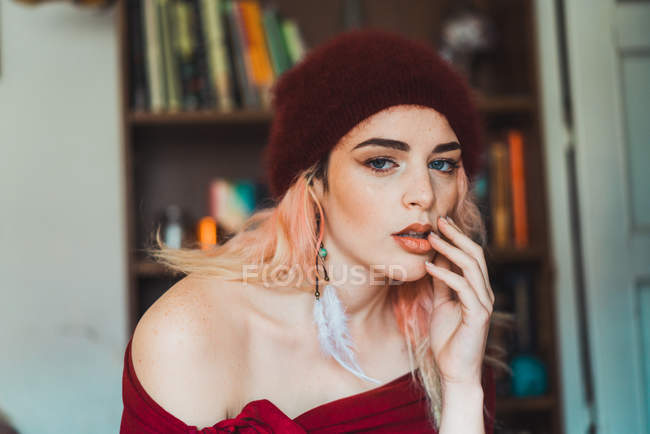 Attractive woman with pink hair touching lips and looking at camera — Stock Photo