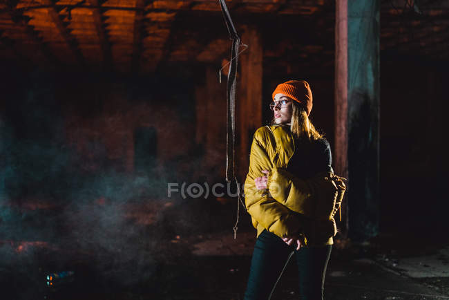 Frau posiert in gelber Jacke vor verlassenem Gebäude — Stockfoto