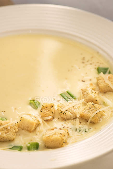 Assiette avec soupe crémeuse savoureuse servie avec croûtons et laitue . — Photo de stock
