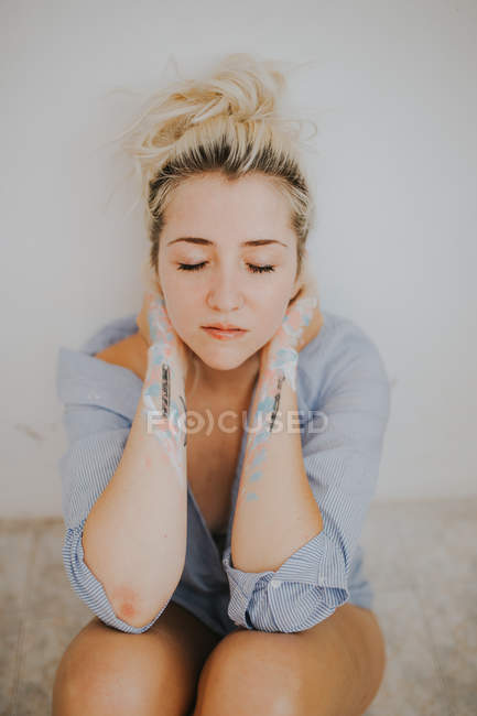 Приваблива жінка в чоловічій сорочці, сидячи з закритими очима — стокове фото