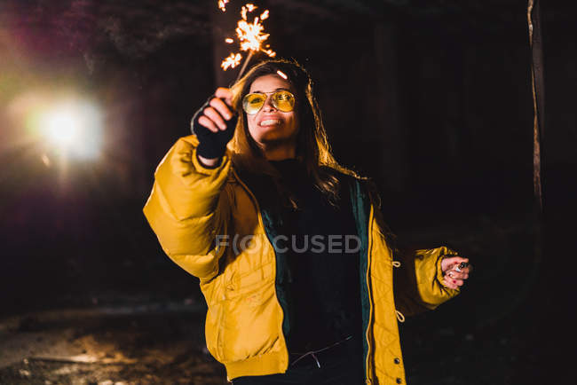 Lächelnde Frau posiert mit brennender Fackel — Stockfoto
