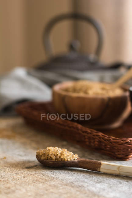 Vista ravvicinata di cucchiaio da ciotola con zucchero di canna su vassoio di vimini — Foto stock
