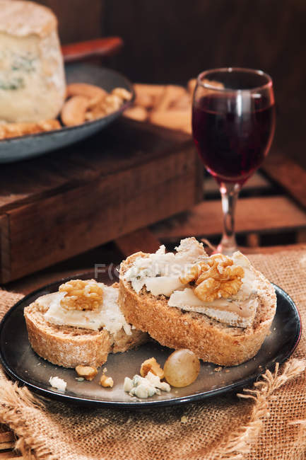 Close up view of slices of bread with cheese and wine — Stock Photo