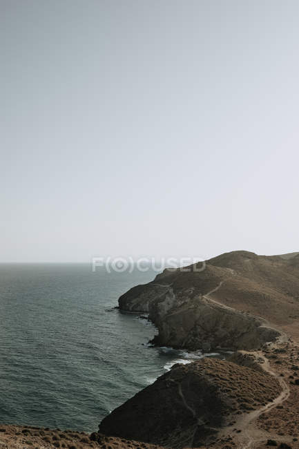 View to coastal rocks and calm sea in gray cloudy day. — Stock Photo