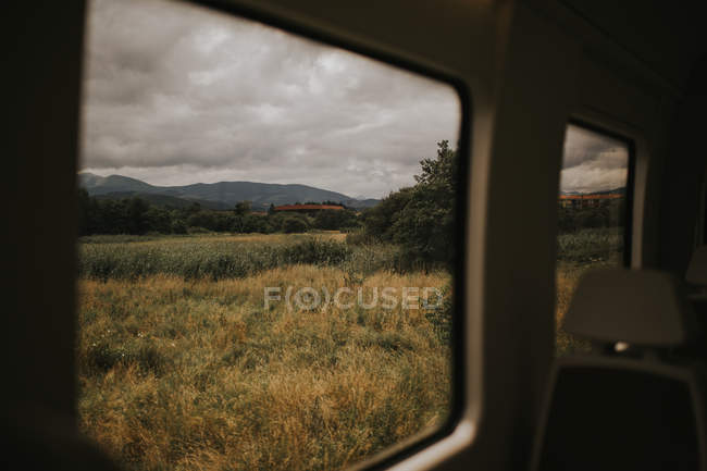 Blick auf trockene Wiese bei bewölktem Tag vom Auto aus gesehen — Stockfoto