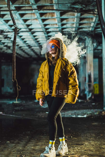 Frau läuft in verlassenem Gebäude und dampft — Stockfoto