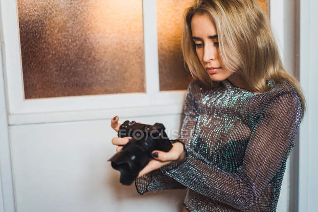 Young blonde woman looking at camera in hands — Stock Photo