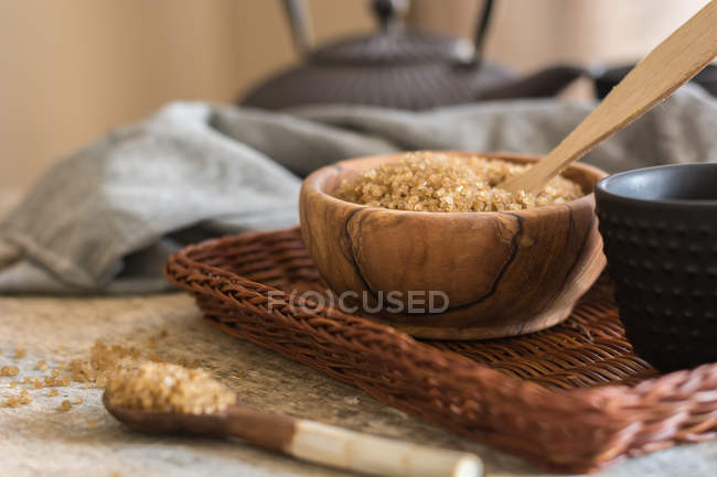 Ложка за мискою з коричневим цукром на плетеному лотку — стокове фото