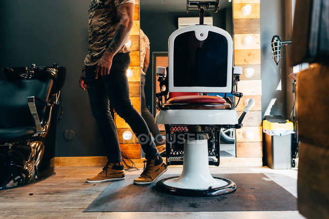 Обрізаний чоловік позує біля перукарського стільця — стокове фото