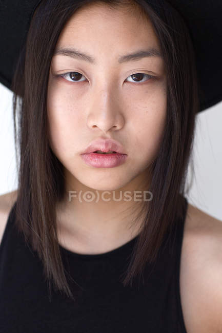 Porträt einer jungen Frau mit Hut und Blick in die Kamera — Stockfoto