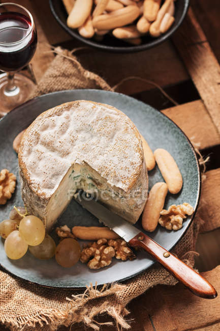 Close up view of cheese with bread and wine on wooden tray — Stock Photo