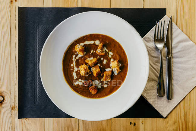 Directly above view of vegetables cream with fried bread pieces on plate — Stock Photo